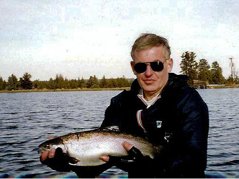 Man from float tube holding his catch.